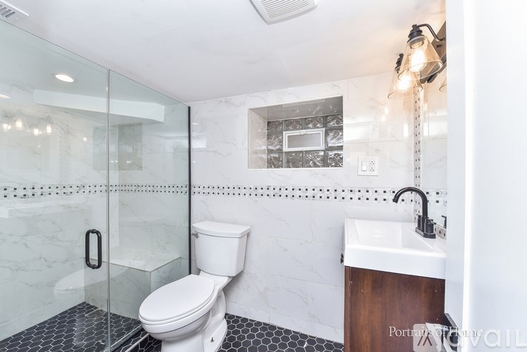 A white toilet sits in a bathroom with a glass shower door.