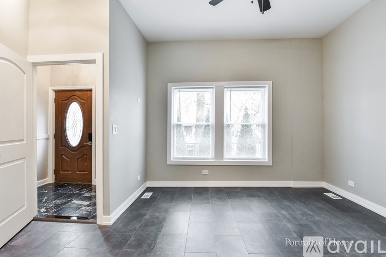 A room with a wooden door and a window with white blinds.