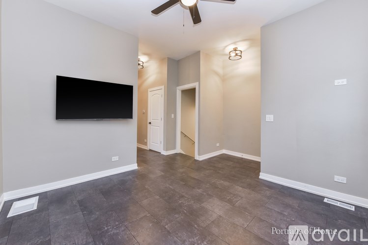 A room with a flat screen TV mounted on the wall and a ceiling fan.