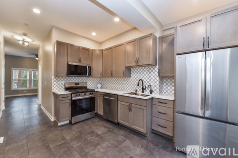 A kitchen with a stove top oven and a refrigerator.