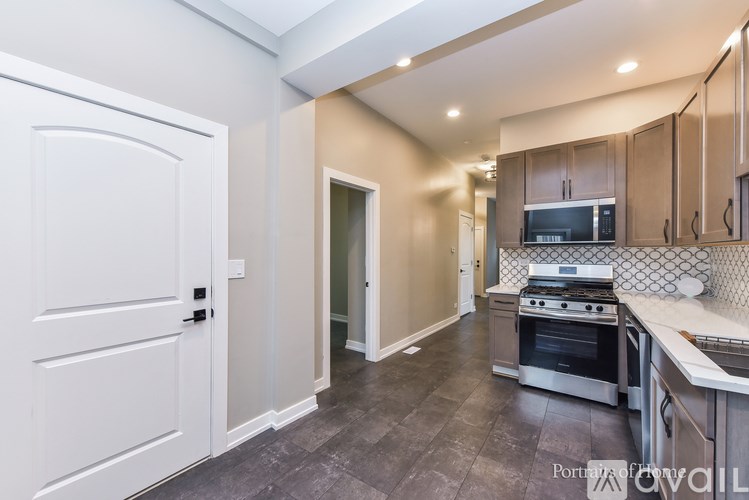 A kitchen with a stove top oven and a white door.