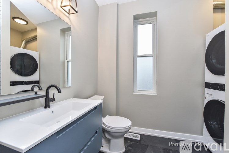 A bathroom with a white sink, toilet, and a window.
