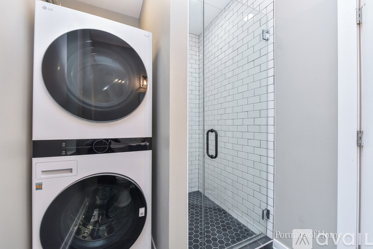 A modern washing machine is placed in a small bathroom.