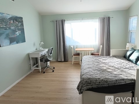 A bedroom with a bed, desk, and chair.