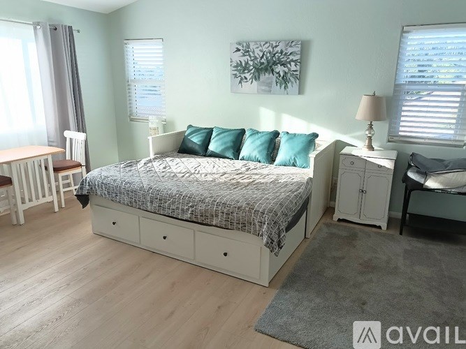 A bedroom with a bed, nightstand, and chair.