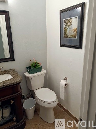 A white toilet sits next to a sink in a bathroom.