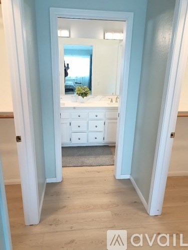 A bathroom with a mirror, sink, and a rug.