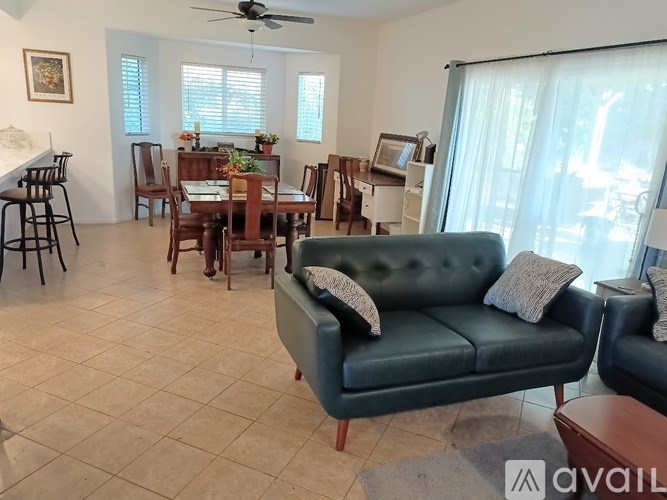A living room with a couch, chairs, and a dining table.