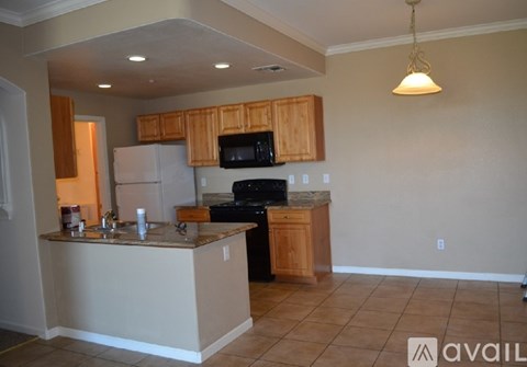 A kitchen with a black stove top oven and wooden cabinets.
