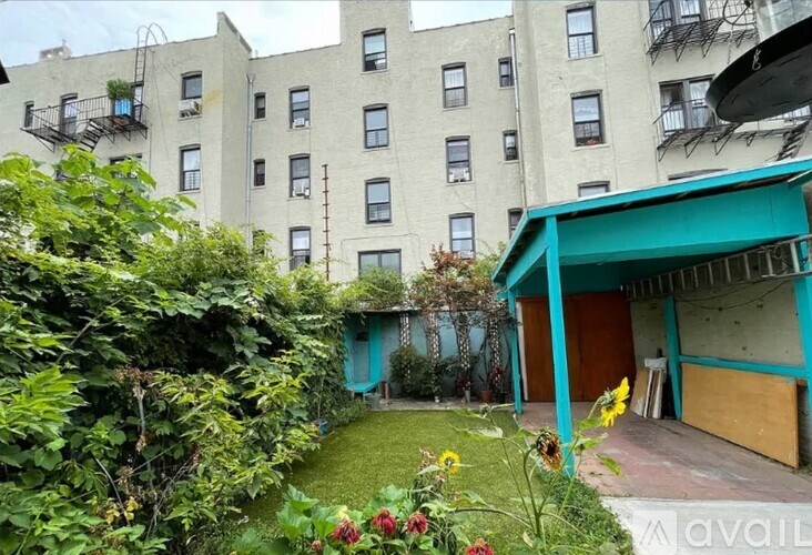 A garden area in front of a building with a blue awning.