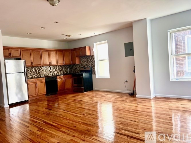 A kitchen with wooden floors and a refrigerator.