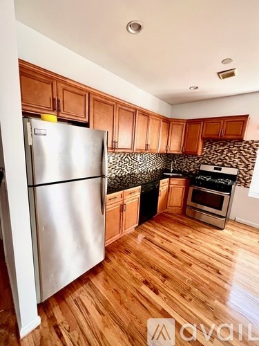 A kitchen with wooden cabinets and a stainless steel refrigerator.