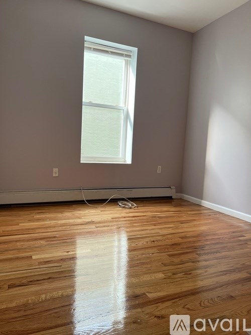 A room with wooden flooring and a window.
