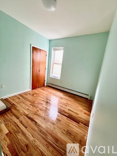 A room with wooden flooring and a window.