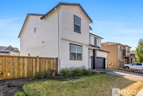 A white house with a wooden fence in front of it.