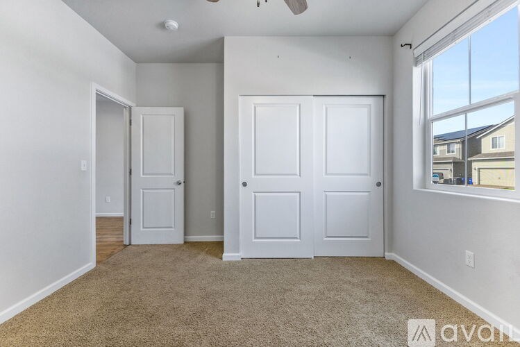 A room with two white doors and a carpeted floor.