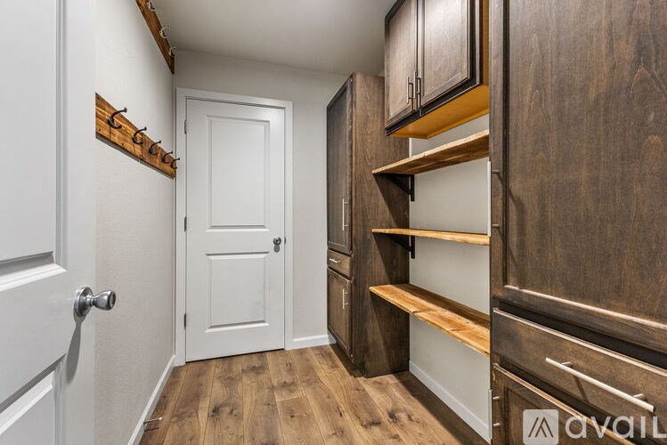 A hallway with a white door and a wooden floor.