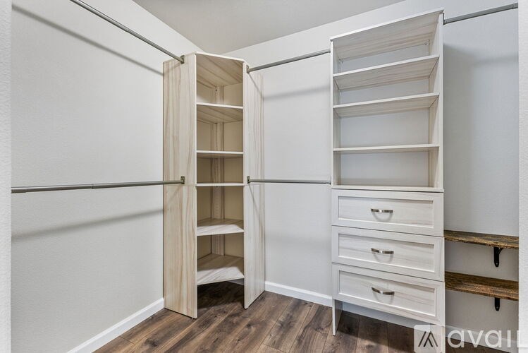 A white closet with drawers and shelves is open.