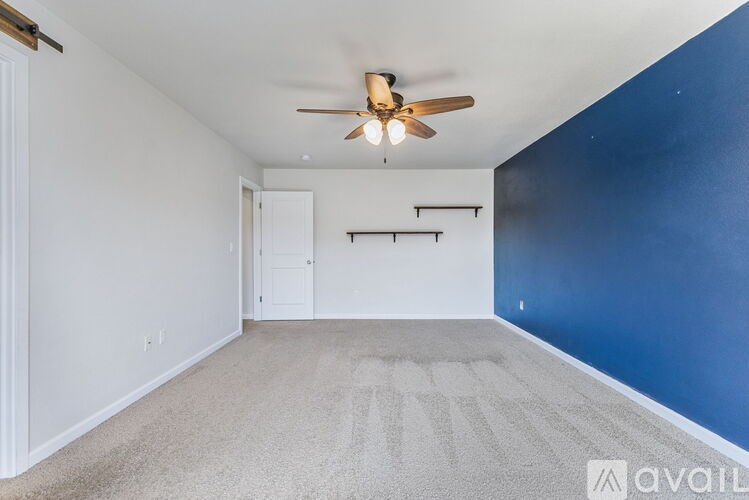 A room with a ceiling fan and a carpeted floor.