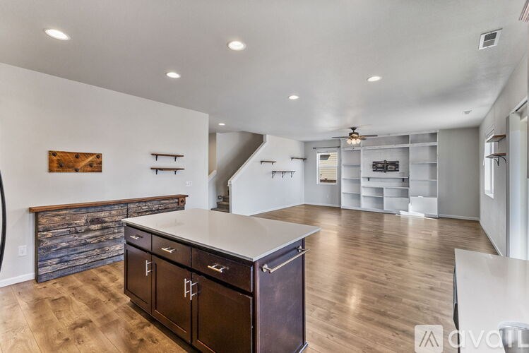A modern kitchen with dark wood cabinets and a white countertop.