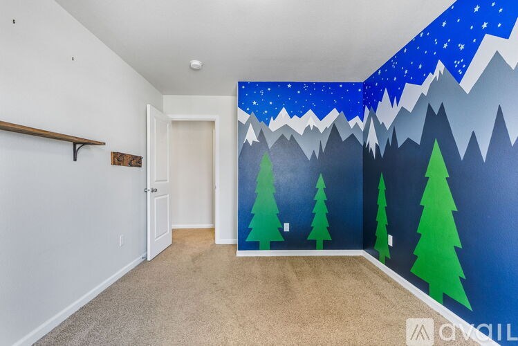 A room with a wall mural of a mountain landscape.