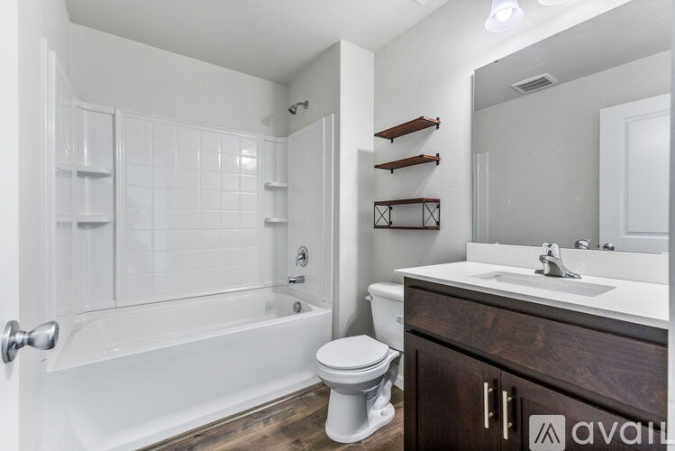 A bathroom with a white tub, toilet, and sink.