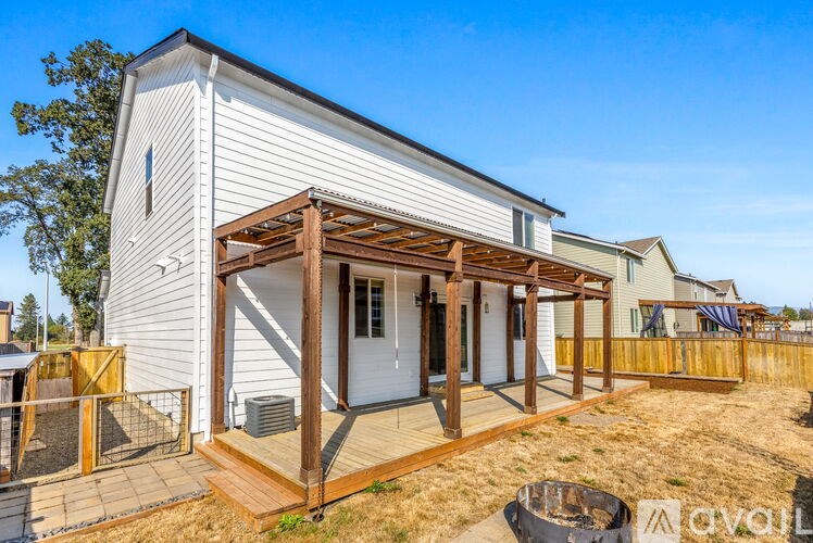 A white house with a wooden deck and a covered patio area.