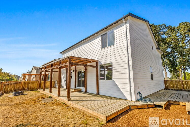 A house with a wooden deck and a white exterior is available for sale.