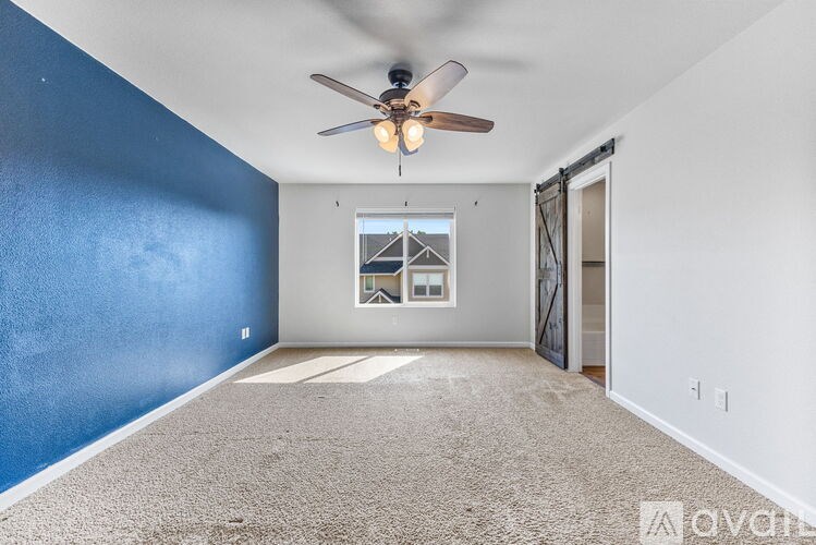 A room with a ceiling fan and a window.