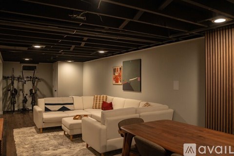 A living room with a white couch and a wooden table.
