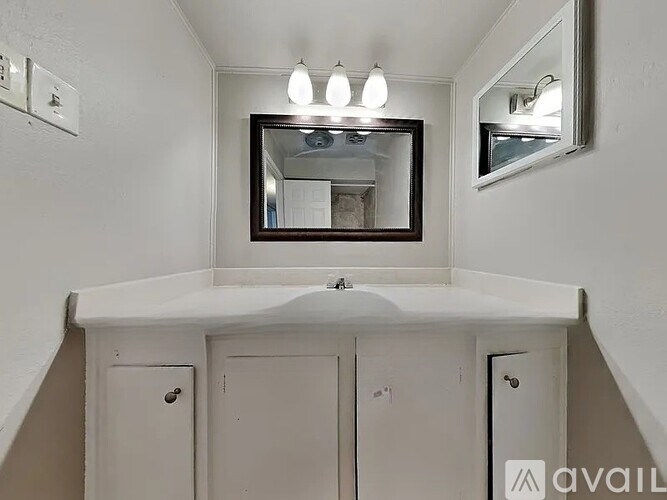 A bathroom with a sink, mirror, and medicine cabinet.