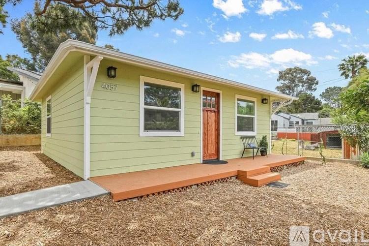 A small house with a red door and a porch.