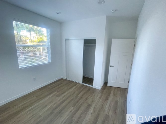 A room with a window and a door is available for rent.