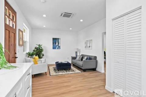 A living room with a grey couch, a white countertop, and a rug on the floor.
