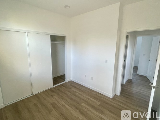 A room with wooden flooring and white walls.