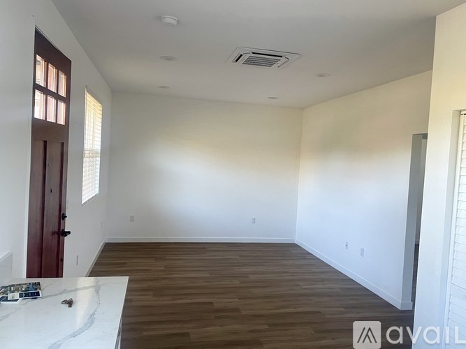 A room with wooden flooring and a white countertop is available for rent.