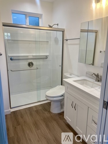 A bathroom with a toilet, sink, and walk-in shower.