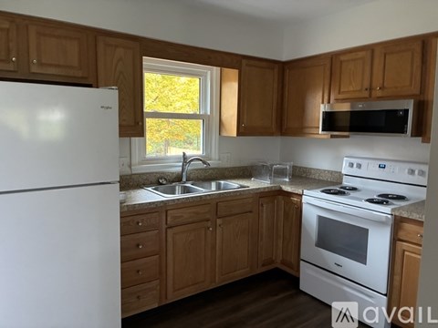 A kitchen with wooden cabinets and white appliances.