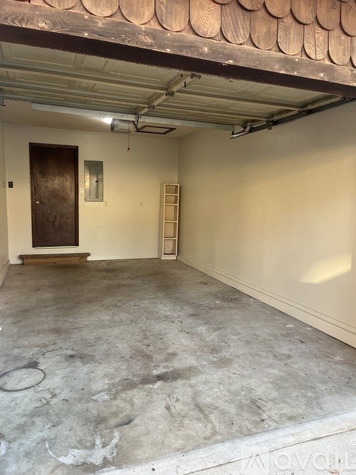 A room with a concrete floor and a wooden door.