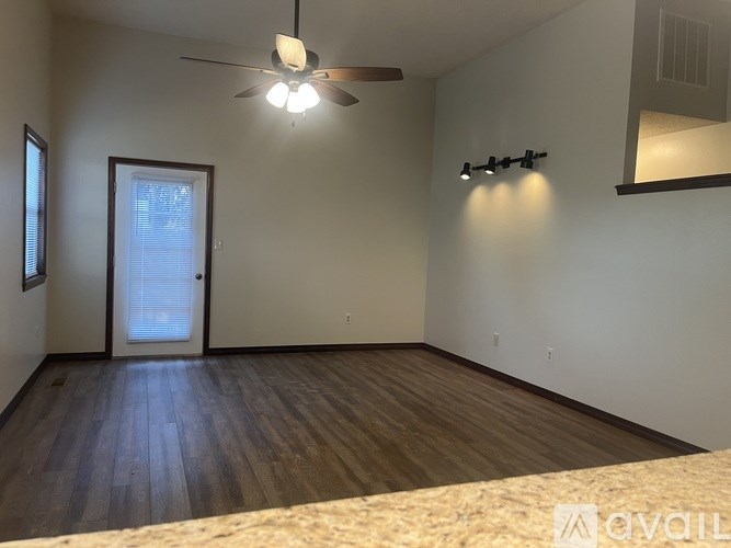 A room with a ceiling fan and a door.