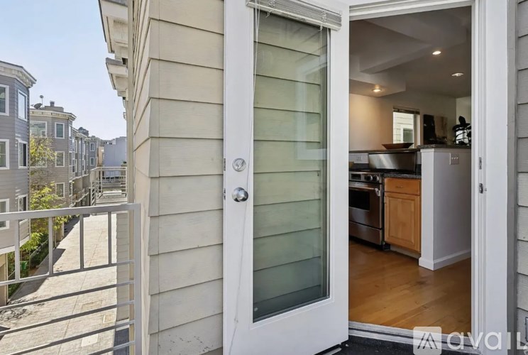 A view of a balcony with a doorway leading to a kitchen.