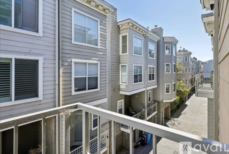 A row of townhouses with balconies and a clear sky.