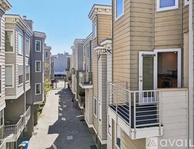 A row of townhouses with balconies and doors are shown.
