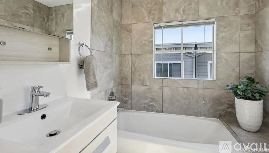 A bathroom with a white sink and a white bathtub.