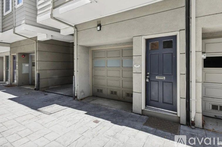 A grey building with a blue door and a sign that says "available".