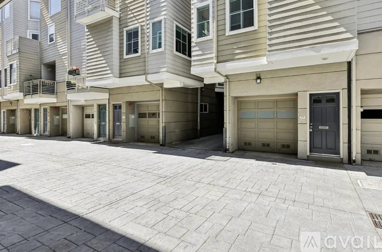 A row of modern townhouses with garages and balconies.