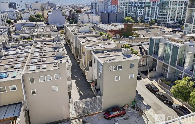 A red car is parked on a street in a residential area.