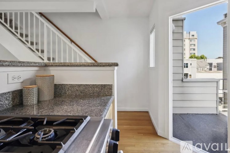 A kitchen with a stove top oven and a view of the outside.