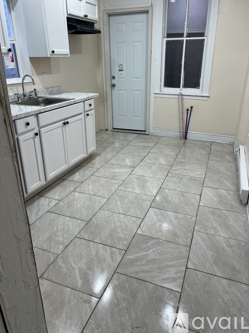 A kitchen with white cabinets and a white door.