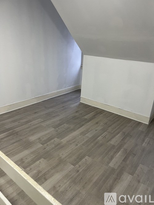 A room with wooden flooring and white walls.